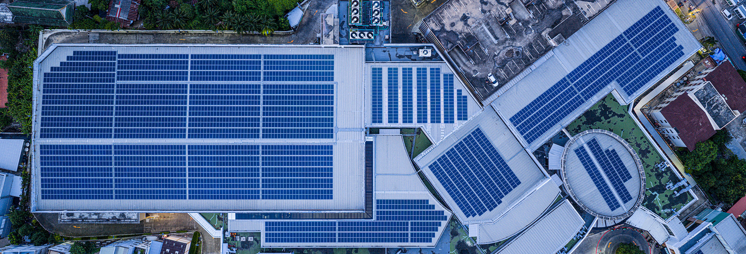 Gewerbekunden_Systemloesungen Eine weitläufige Photovoltaikanlage auf den Dächern eines großen Industrie- oder Gewerbekomplexes.